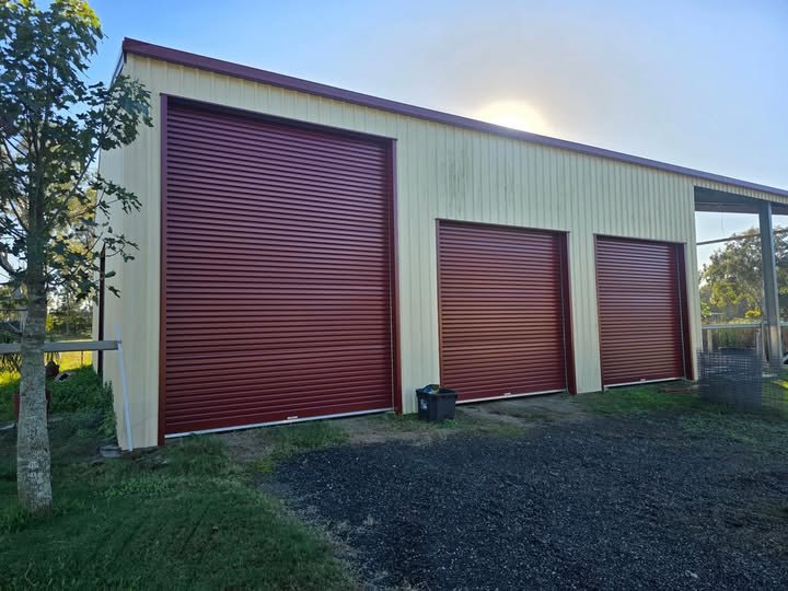 Three red roller doors fitted to a large Gold Coast shed